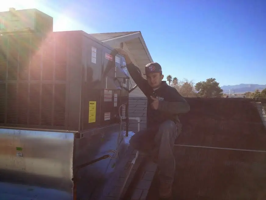 HVAC technician performing AC Tune-Up on a rooftop unit in Woodcliff Lake
